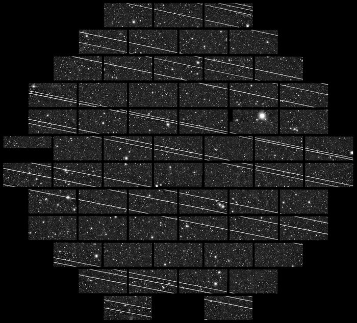 Mosaico del cielo estrellado, cruzado de lado a lado por finas líneas rectas blancas a intervalos irregulares.
